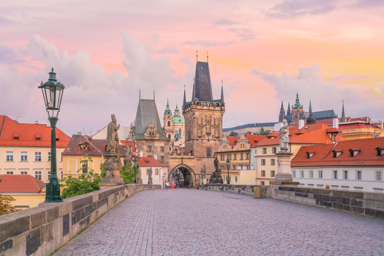 Pohled na Karlův most v Praze při východu slunce s historickými sochami